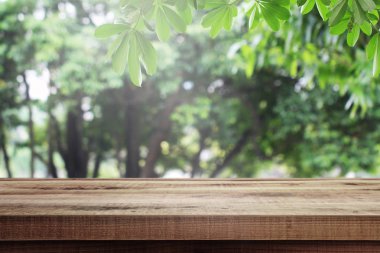 Tahta masa ve bulanık yeşil bahçe arka planı.