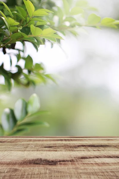 木製テーブルとぼやけた緑の自然庭園の背景 — ストック写真