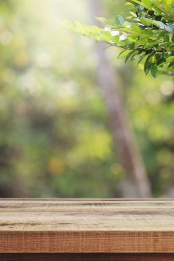 Tahta masa ve bulanık yeşil bahçe arka planı.