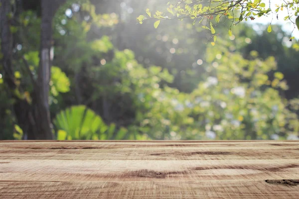 Tahta boş ve bulanık yeşil bahçe arka planı.