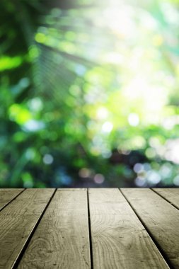 Bulanık yeşil bokeh ve ahşap masa arkaplanı.