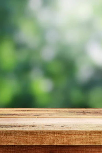 Bulanık yeşil bokeh ve ahşap masa arkaplanı.