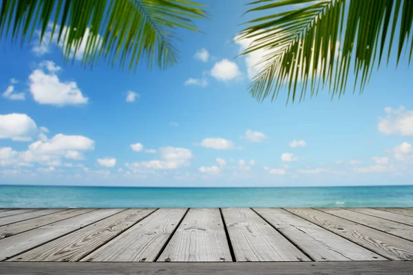 Boş ahşap ve tropik plaj arka planında palmiye ağaçları, yaz mevsimi.
