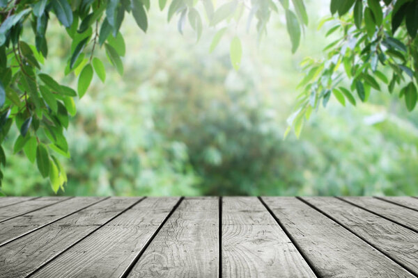 Wooden table and blurred green leaf nature in garden background. 