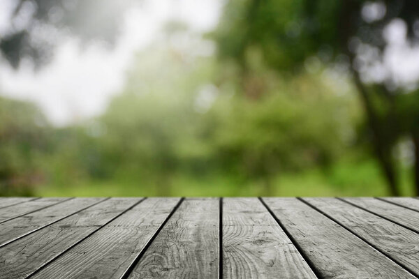 Empty wooden table and blurred nature garden background. 