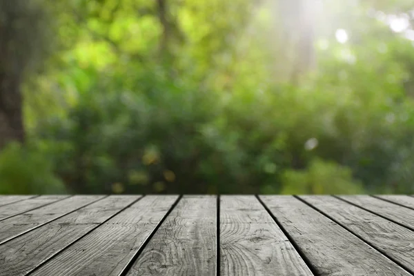 Bulanık yeşil bokeh ve ahşap masa arkaplanı.