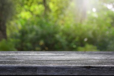 Bulanık yeşil bokeh ve ahşap masa arkaplanı.