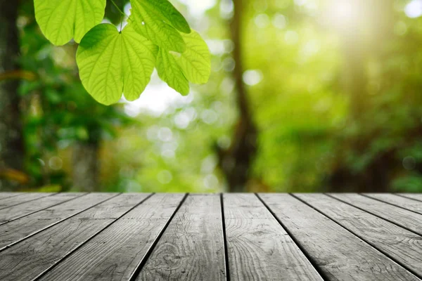Ahşap masa ve bulanık yeşil yaprak arka planda.. 