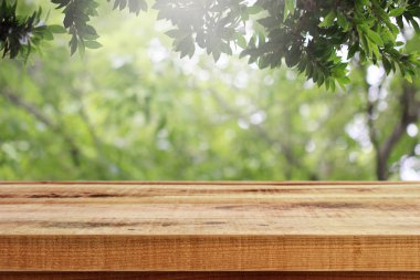 Ahşap masa ve bahçe arka planında bulanık yeşil doğa. 