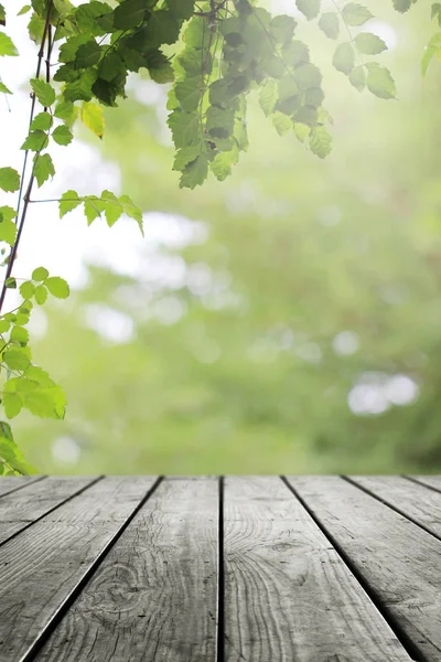 Ahşap masa ve bulanık yeşil yaprak arka planda.. 