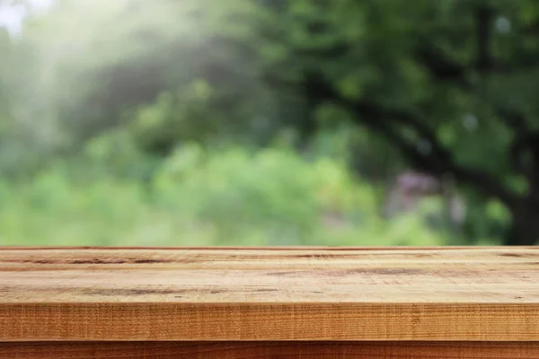 庭の青抽象的な緑のボケと木製のテーブルの背景 — ストック写真