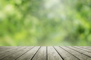 Bulanık yeşil ve ahşap masa arkaplanı.
