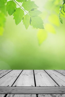 Ahşap masa ve bulanık yeşil yaprak arka planda.. 