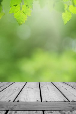 Ahşap masa ve bulanık yeşil yaprak arka planda.. 