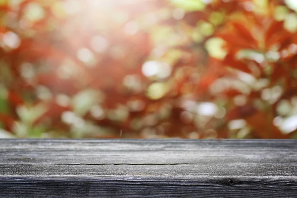 木製テーブルとぼかしぼかし秋の背景 — ストック写真