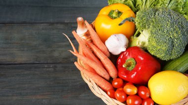 Tahta masa manzaralı sepetin içinde taze organik sebzeler. Sağlıklı gıda konsepti.
