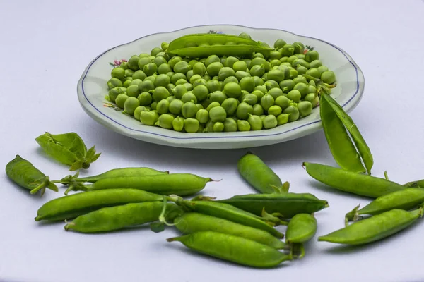 绿色背景 豌豆的背景顶部视图 绿色豌豆在碗中的白色背景复制空间 新鲜的有机豌豆在圆形的白盘上 蔬菜收获 — 图库照片