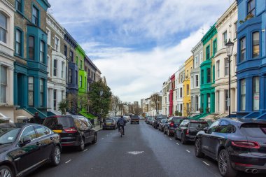 Notting Hill, Londra 'da renkli evleri olan bir yerleşim yeri. Tipik İngiliz evleri mavi, pembe, sarı ve beyaz renklerle ön cephede. İngiliz Pastel Binası. Emlak konsepti şehir manzarası.
