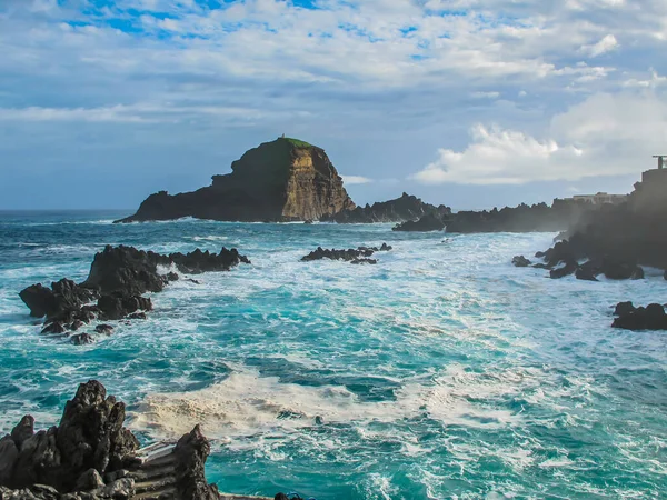 Waves and wind on the coast of the Atlantic Ocean in Porto Moniz, Madeira Island,Portugal.Landscape with natural volcanic formation pools,turquoise cold water,rocky seashore. Wanderlust travel concept