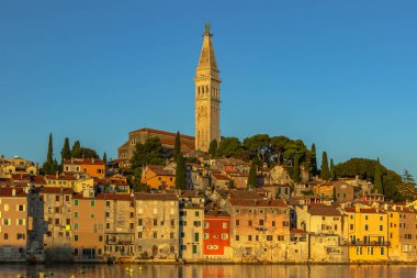 Rovinj, Istria, Hırvatistan. Adriyatik Denizi kıyısındaki kentin manzarası. Popüler turizm merkezi ve balıkçı limanı. Gün doğumunda kaldırım taşı sokakları, renkli evler ve kilise kulesi olan eski bir kasaba.