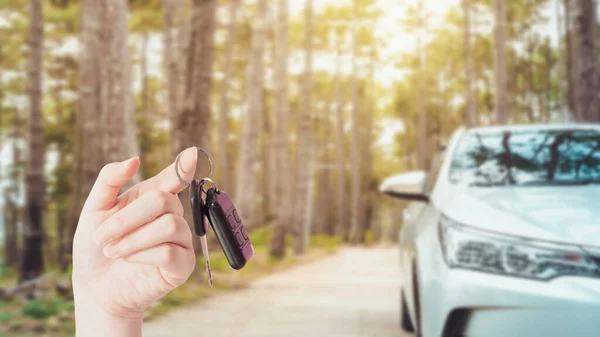 El bilgisayarı anahtarı ya da kullanım desteği online uygulama araba ya da yeni normal bir iş için sigorta yumuşak odaklı modern kompakt otomobille country road arka planında