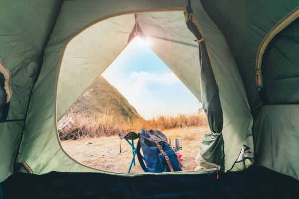 wanderlust and relax in nature with camping tent and backpack on top of mountain on spring and summer season