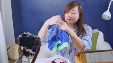 4K vdo asyalı kadın çevrimiçi satıcı konuşması ve Vdo canlı yayın sırasında kamerayla online alışveriş yapan müşterilere spor kıyafetleri satışı