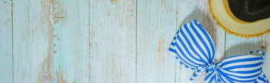 Web afişi ve düz bir yaz mevsimi mayolu ve plaj aksesuarlı klasik mavi ahşap arka planda.