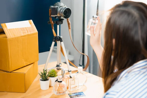 Asyalı çevrimiçi kadın konuşmaları ve video canlı yayın sırasında kamerayla online alışveriş müşterilerine parfüm satışı.