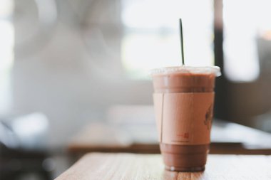 Buzlu latte 'den yaz tatili aktivitesi modern ve rahat kahve dükkanının arka planındaki masada.