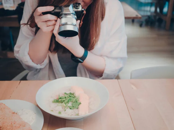 woman power with hobby and lifestyle concept from beauty woman photographer hand hold camera and take photo to morning food in restaurant with copy space background