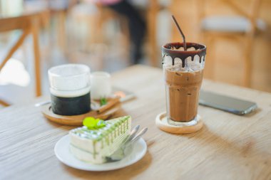 Buzlu kahve, kek ve tatlı ahşap masada