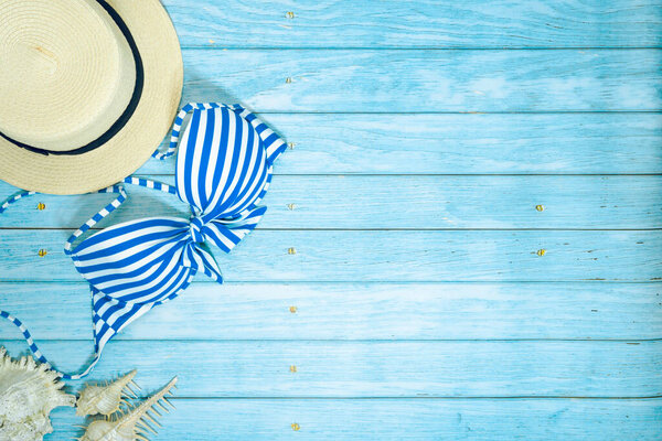 web banner and flat lay summer time with swimsuit and beach accessories on blue wooden background