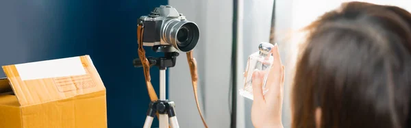 Asyalı çevrimiçi kadın konuşmaları ve video canlı yayın sırasında kamerayla online alışveriş müşterilerine parfüm satışı.