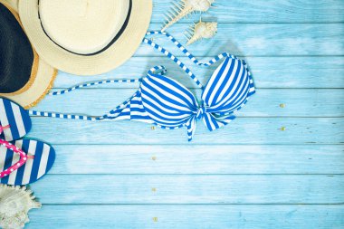 Web pankartı ve düz bir yaz mevsimi mayolu ve plaj aksesuarlı mavi ahşap arka planda