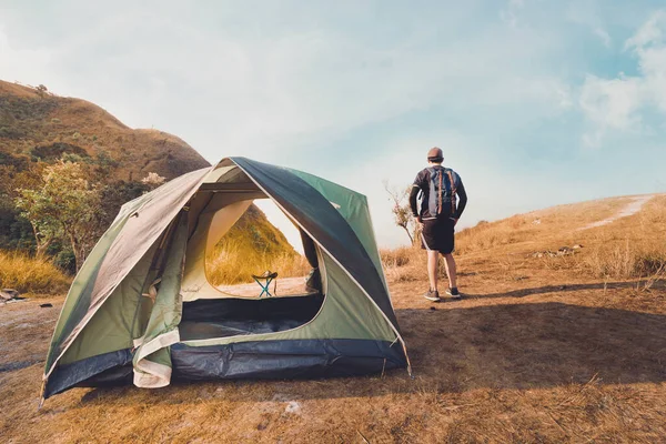 wanderlust and relax in nature with hiker man camping on top of mountain on spring and summer season