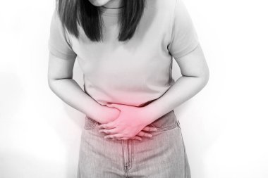 Beyaz, izole edilmiş portre karın ağrısı ve 30-40 yaş arası, tek renkli ve kırmızı noktalı bir kadının acı hissi.