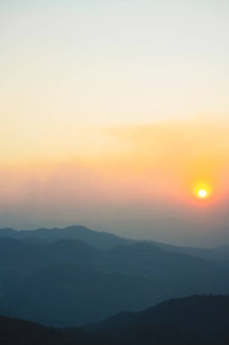 Günbatımı ve alacakaranlık gökyüzü ve dağ katmanıyla manzara ve seyahat kavramı