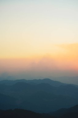 Günbatımı ve alacakaranlık gökyüzü ve dağ katmanıyla manzara ve seyahat kavramı