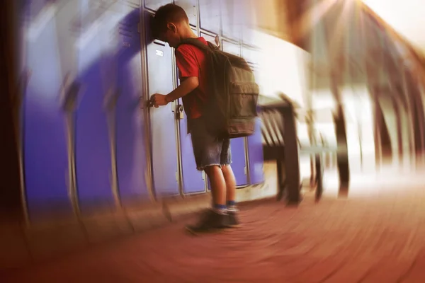 男孩靠在储物柜中在学校的走廊全长 — 图库照片