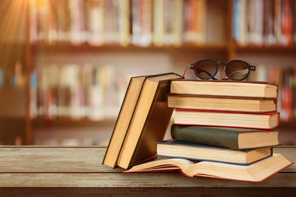Brille Auf Bücherstapel Gegen Bücherregal — Stockfoto