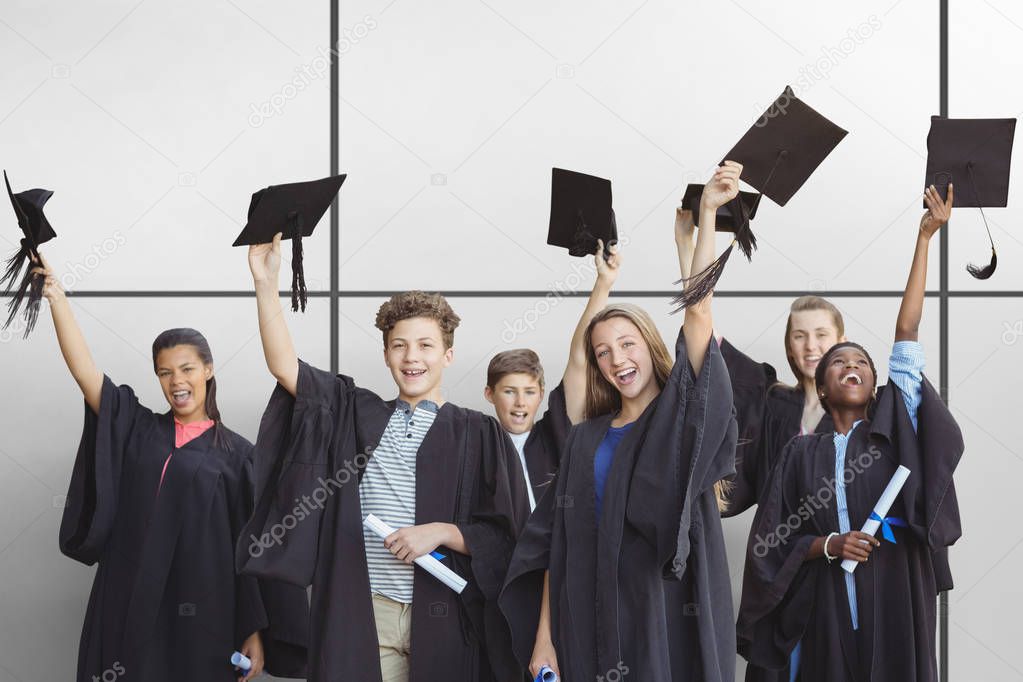 Students holding mortarboards against white tiling