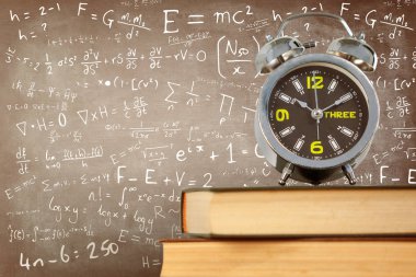 Çalar saat kitap kara tahta karşı yığını yerleştirilen