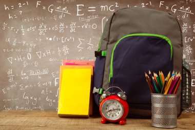 Kara tahta karşı ahşap masa çalar saat tarafından okul malzemeleri