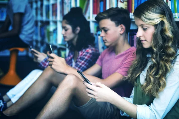 Μαθητές Χρησιμοποιούν Κινητό Τηλέφωνο Στη Βιβλιοθήκη Στο Σχολείο — Φωτογραφία Αρχείου