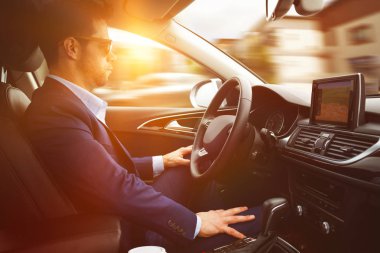 Adam araba kullanıyor.