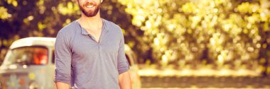 Bir yaz gününde kameraya gülümseyen yakışıklı hipster