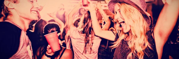 Cheerful friends dancing in nightclub
