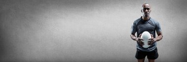 Dijital bileşik gri arka plan ile topa tutan Rugby oyuncusu