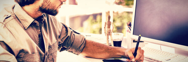 Artist using graphics tablets sitting at desk